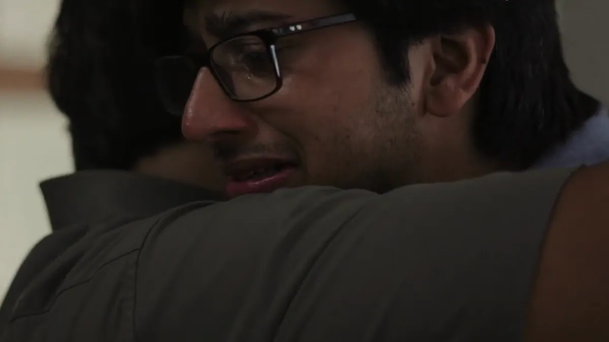A young man in tears embracing his father, from the Google India film about telling a parent of a plan to open a cafe