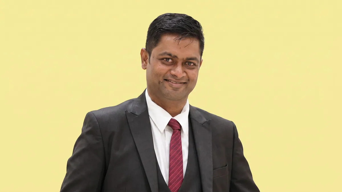 Amit Goel, head of operations for Walkway at Metro Brands, photographed against a flat butter yellow background