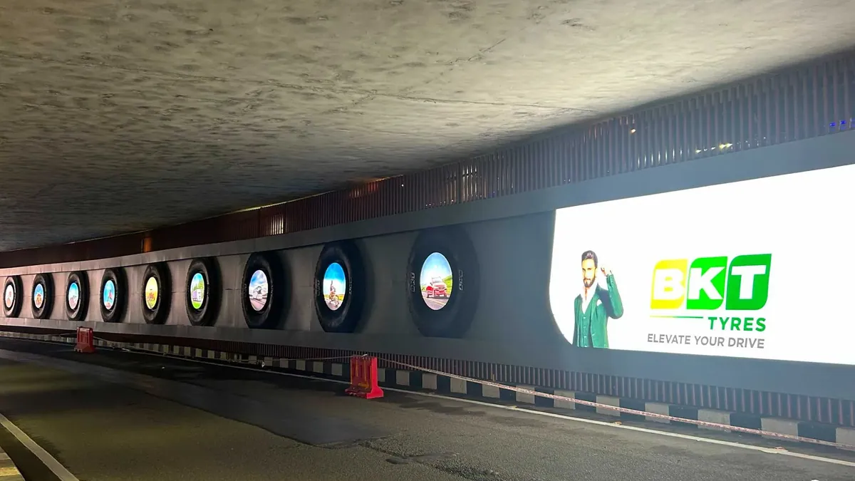 A row of illuminated tyre-shaped displays inside an airport underpass