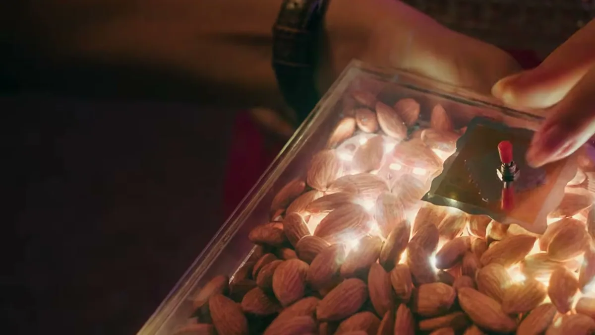 A tray of almonds lit by diyas being handed over, from the California Almonds Badam for EveryBuddy festive film
