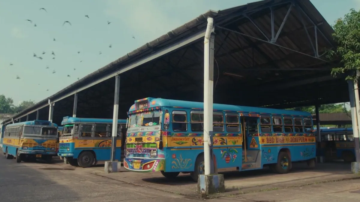 A blue Kolkata bus at a depot with BBD BAGH 103 JADAVPUR painted on its side