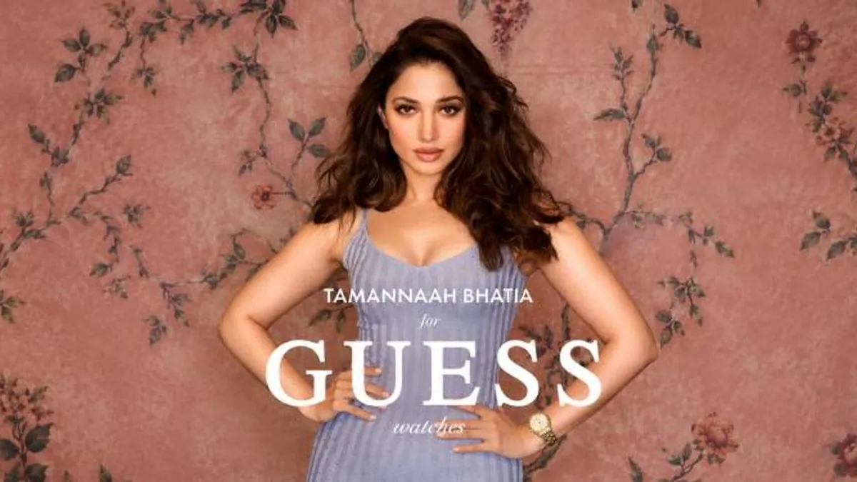 Tamannaah Bhatia in a lilac knit dress and a gold watch against floral wallpaper, in the Guess Watches FW26 campaign visual