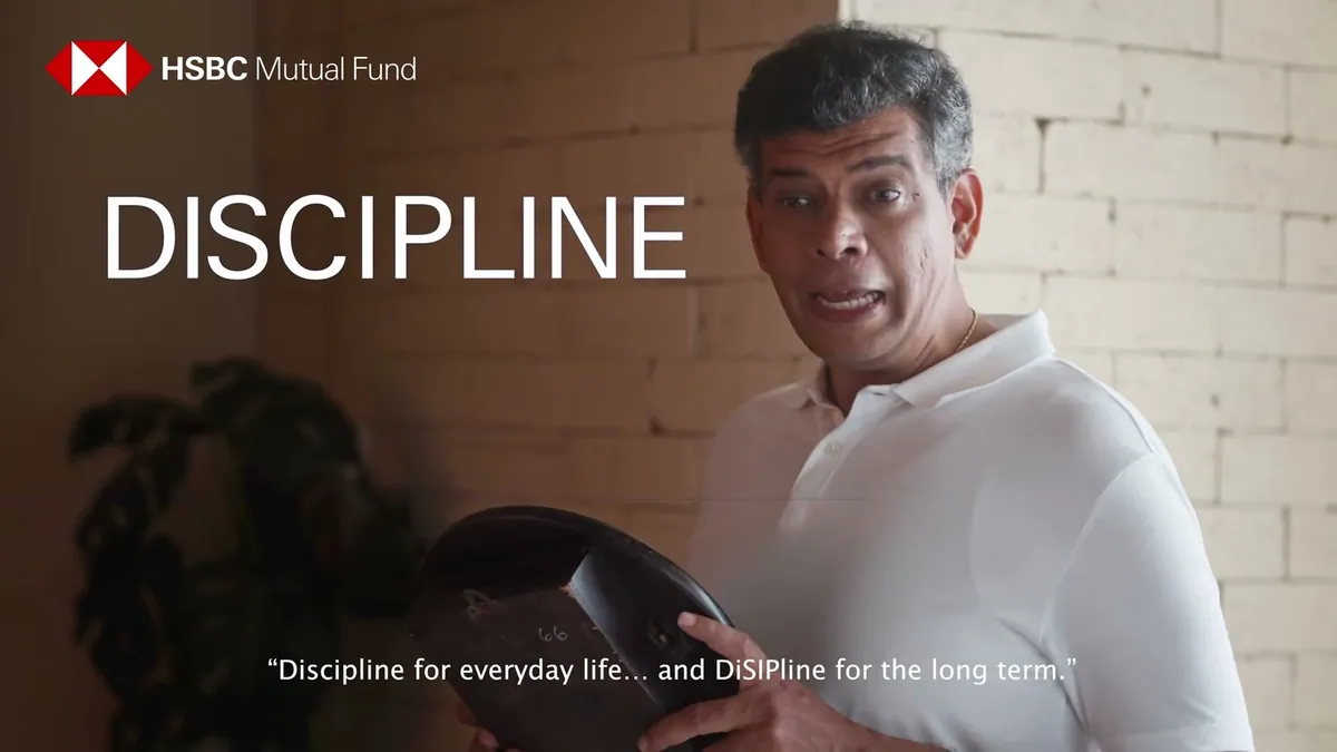 A father figure holding a helmet beside the word DISCIPLINE in HSBC Mutual Fund's StayDiSIPlined film