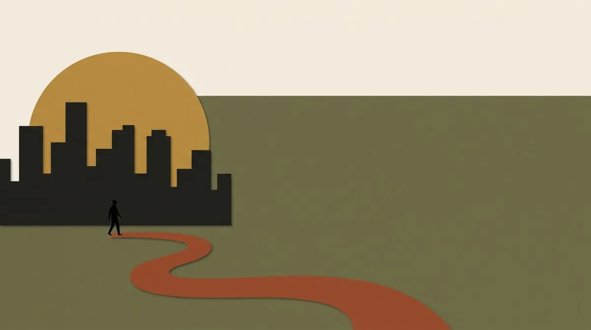A silhouette figure walking away from a small city skyline along a winding path into open space