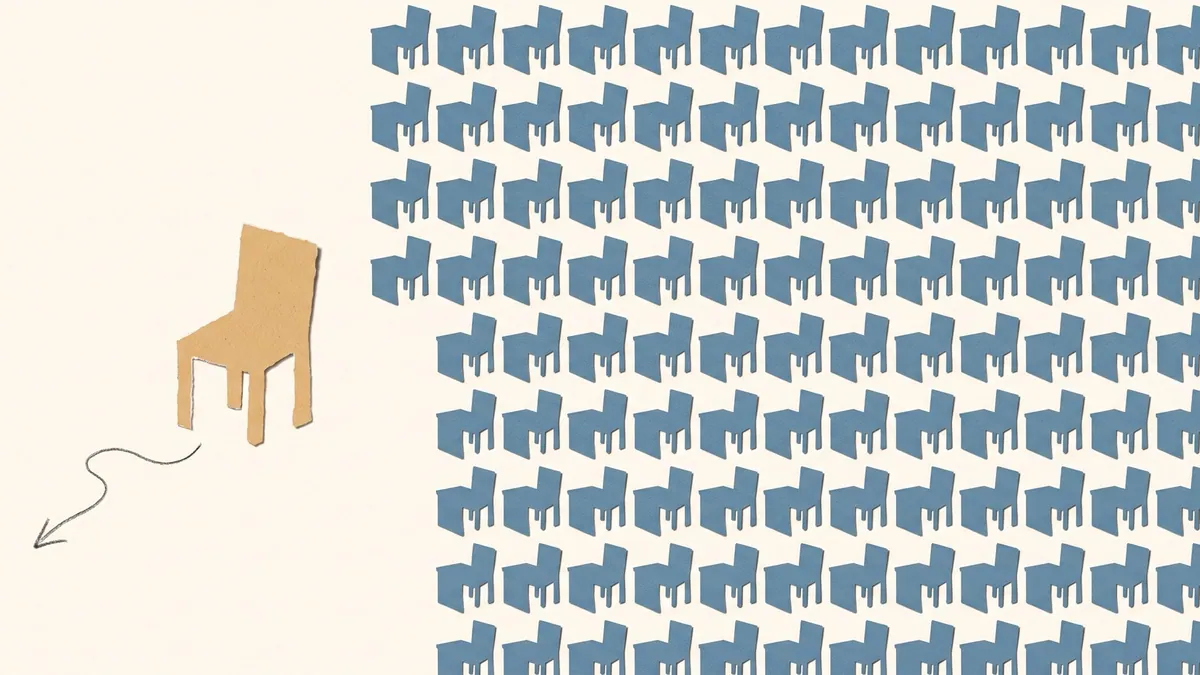 A single chair placed outside a grid of identical desks, in dusty blue and sand