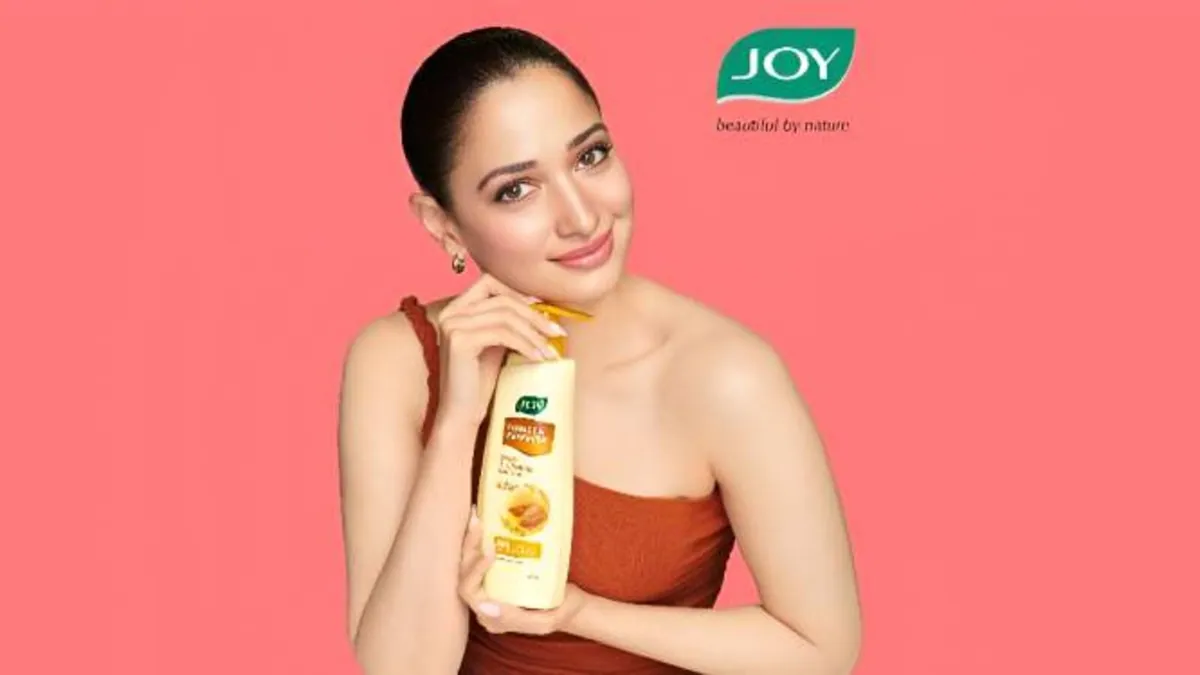 Tamannaah Bhatia holding the Joy Honey and Almonds body lotion, in the brand's new campaign visual