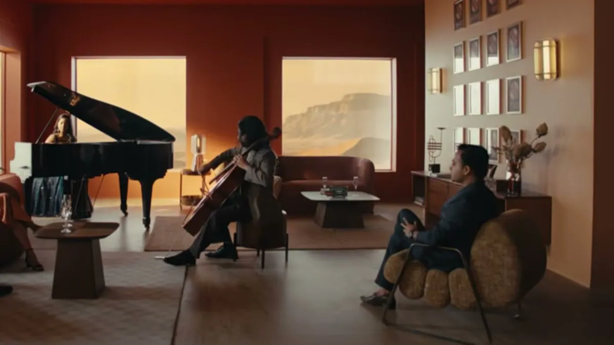A warm terracotta living room with a grand piano and musicians, from the JSW Dulux Velvet Touch Eterna campaign film