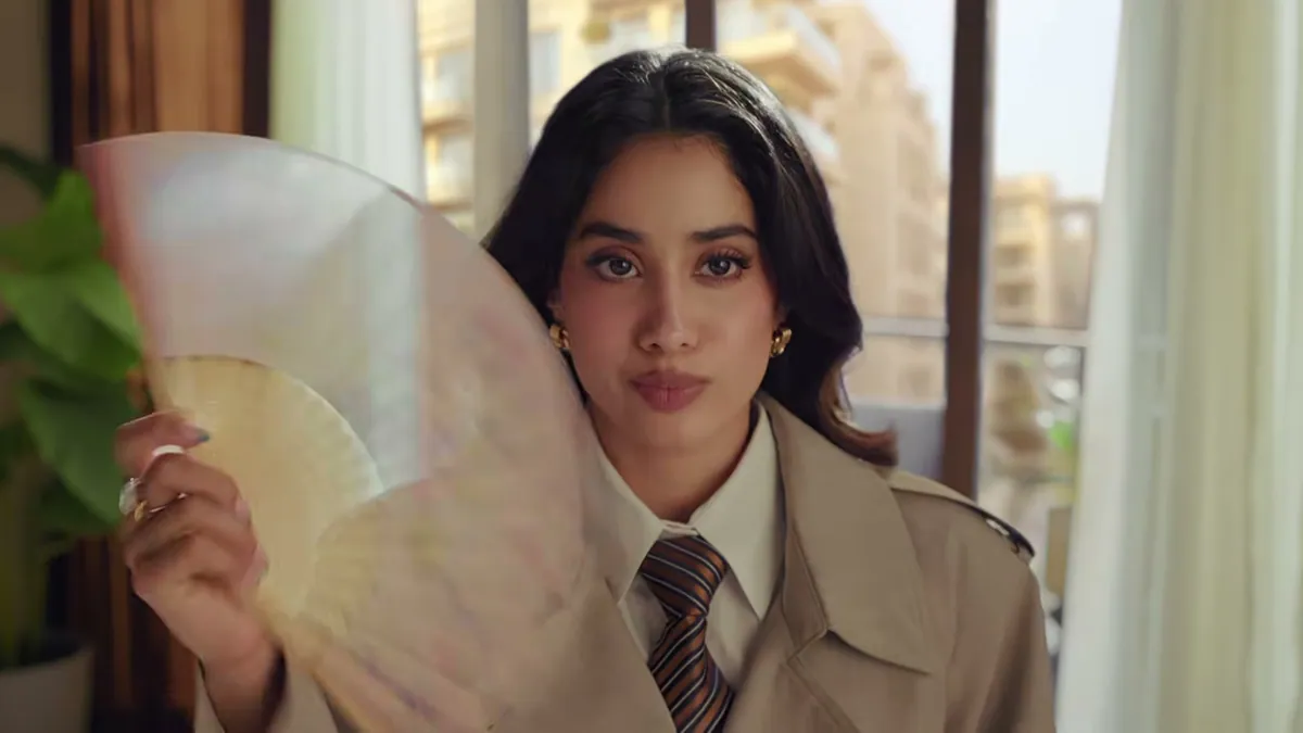 Janhvi Kapoor in a trench coat holding a paper fan, from the King Koil Nothing, but King Koil film