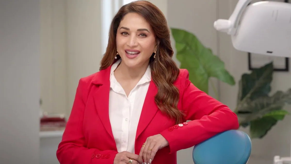 A dental crown and a family portrait frame rendered as halftone paper cutouts, for the Laxmi Dental Illusion Zirconia campaign with Madhuri Dixit