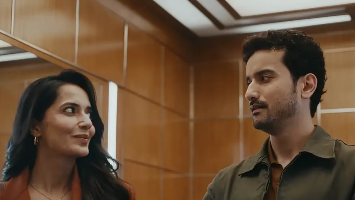 A woman and a man exchanging a look inside a lift, from the returning Imperial Blue Packaged Drinking Water film