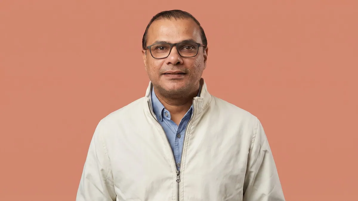 Portrait of Shivraj Shinde in a cream jacket against a flat pastel terracotta backdrop