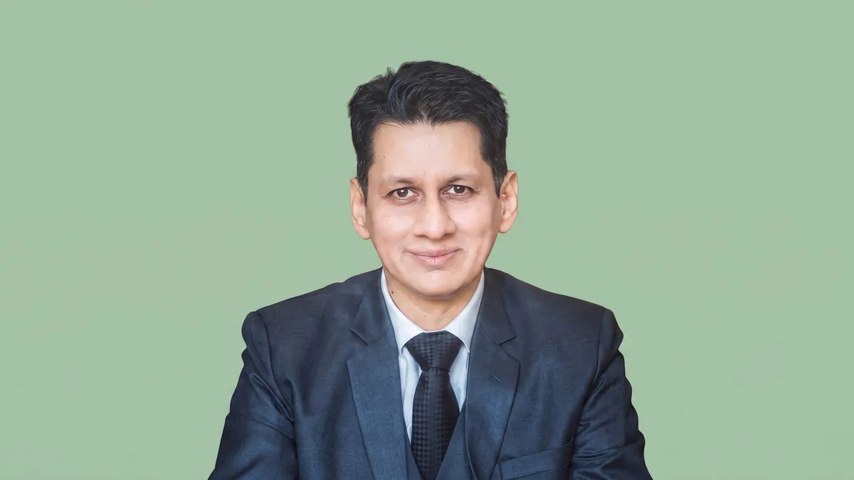 Tariq Ahmad, chief revenue officer international at Netcore, photographed against a flat sage green background