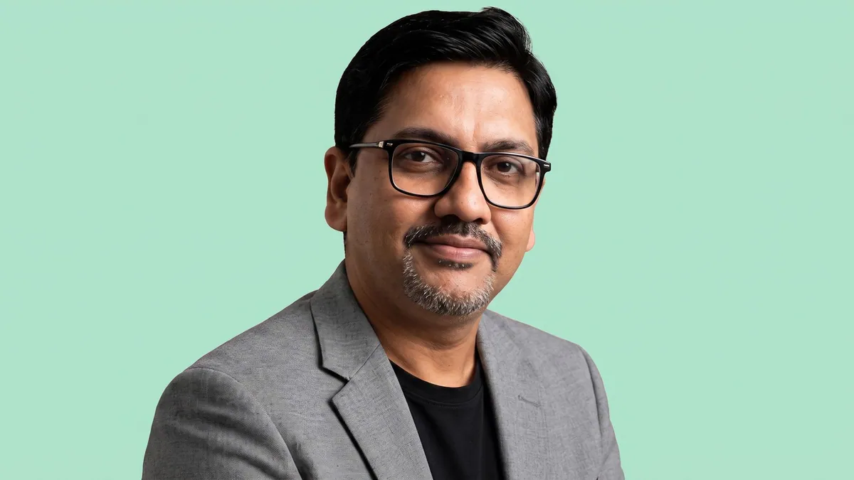 Raj Swaminathan, chief growth officer at BrandStory Group, photographed against a flat mint green background