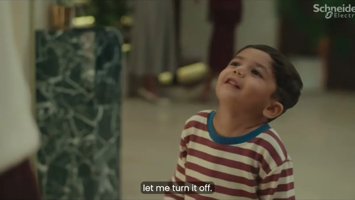 A child looking up at a wall switch, a frame from the Schneider Electric festive film