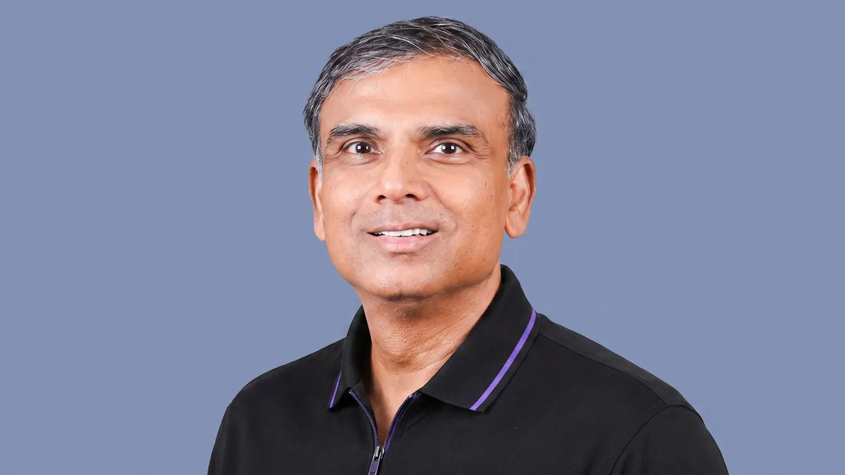 Vikrant Mudaliar, co-founder of Cruise Money, photographed against a flat slate blue background