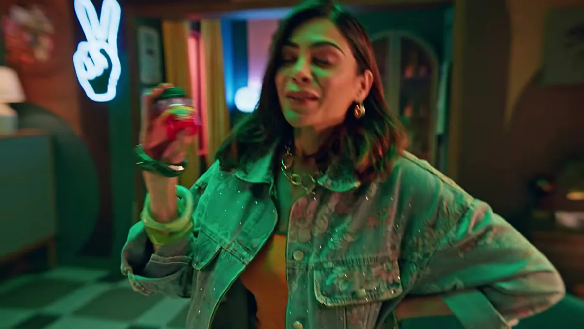 The lead character holding a jar of Zandu Balm in a neon-lit room, in a frame from the Undo With Zandu film